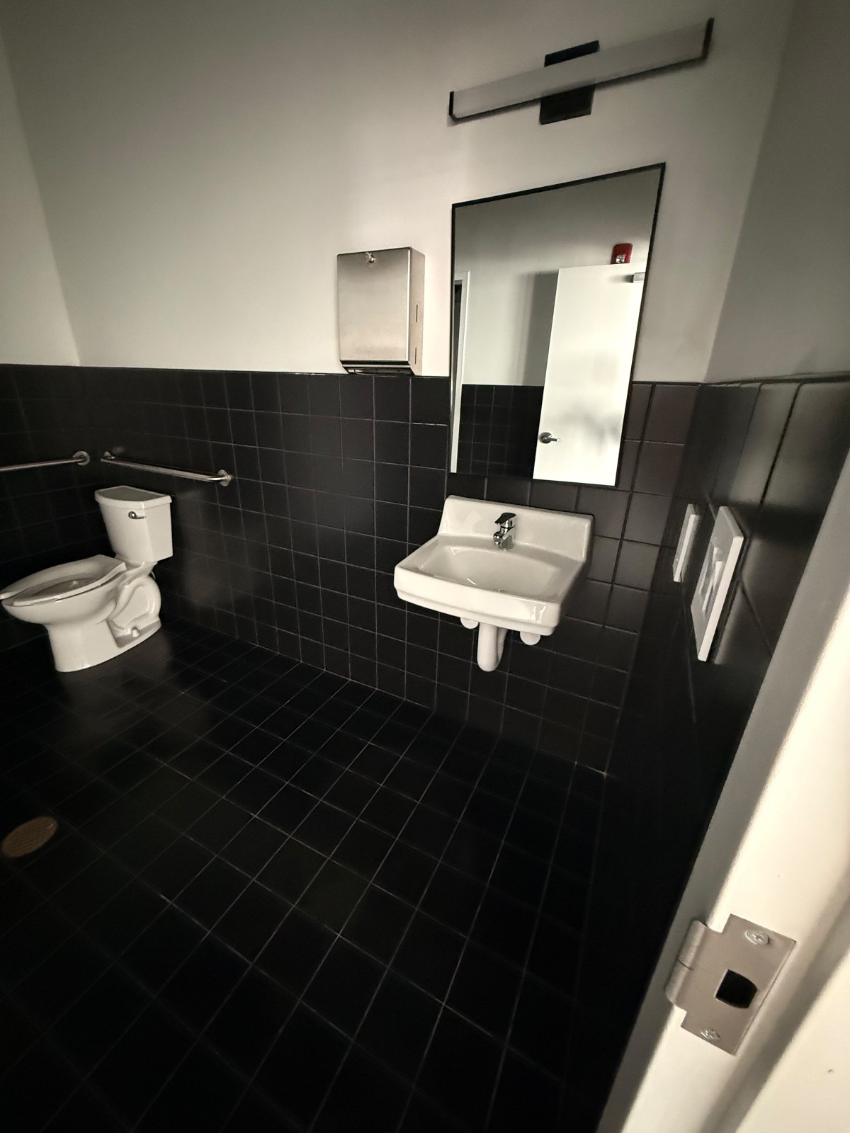 Commercial restroom with black wall and floor tile